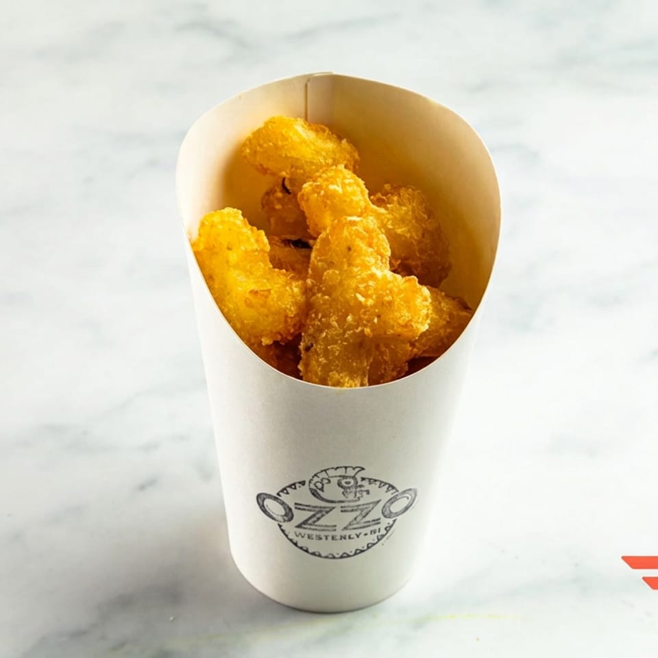Golden fried bites served in a branded paper cup on a white marble surface.