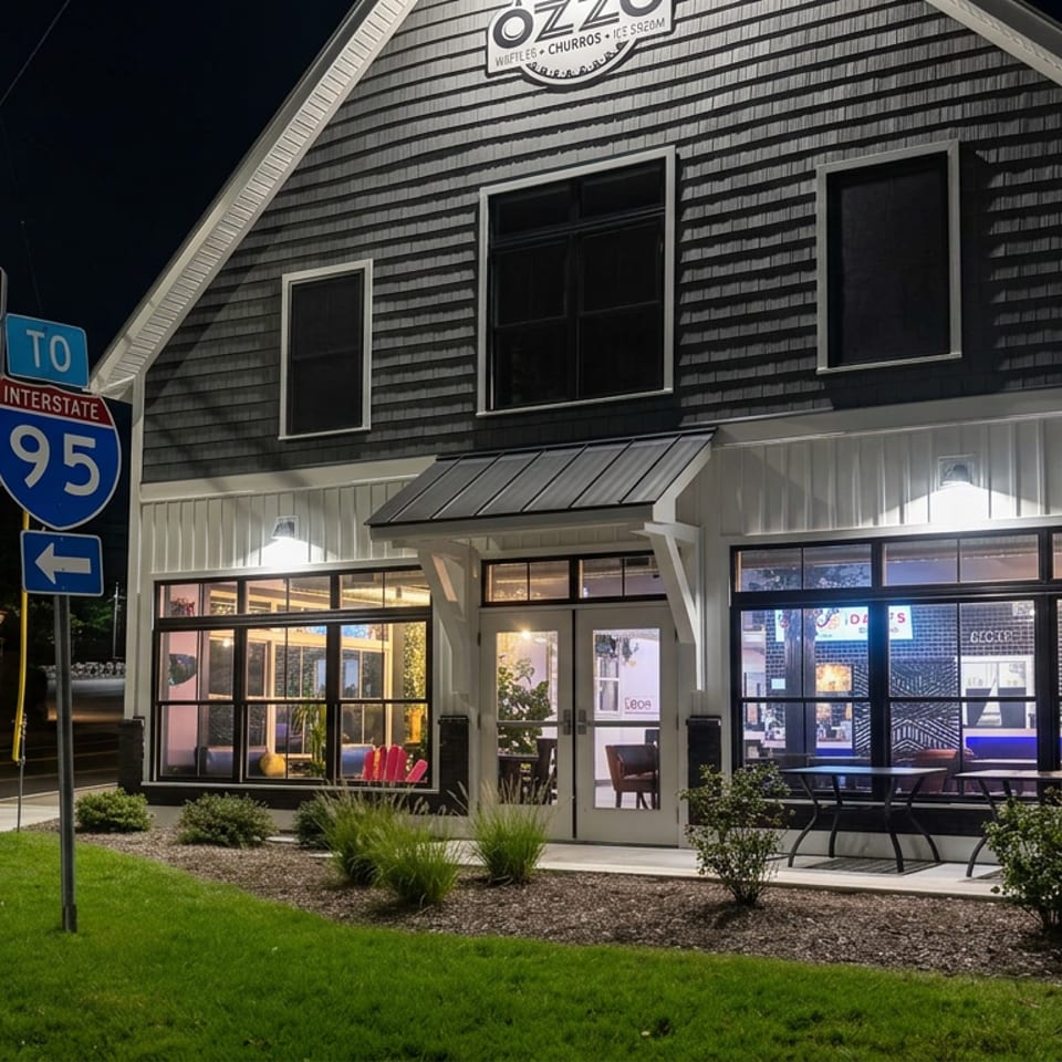 Illuminated OZZO waffle and churros restaurant exterior at night beside South Route 1 and Interstate 95 signs.
